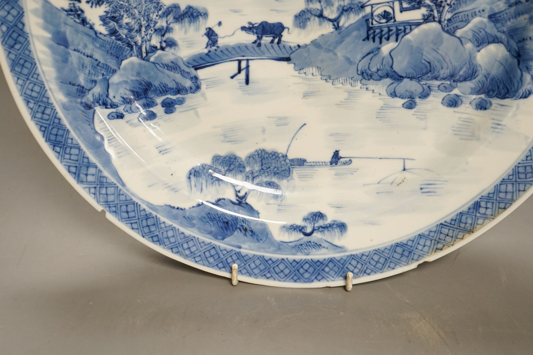 A Chinese blue and white landscape dish, Kangxi mark but 19th century, 36cm